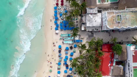 rising drone shot of playa del carmen coastline and resorts with people on the beach