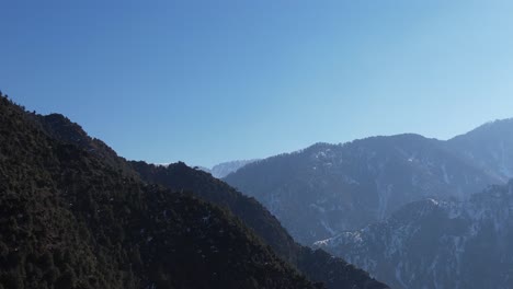 Mountain-ridges-converging-under-a-clear-blue-sky