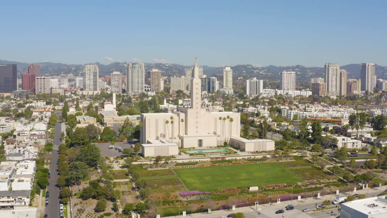 Cinematic aerial fly around beautiful temple with golden statue in the city