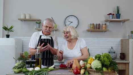 Älteres-Paar-Kocht-Salat-Mit-Gemüse.-Frau-Tanzt-Und-Hält-Frische-Paprikascheiben-Auf-Den-Augen