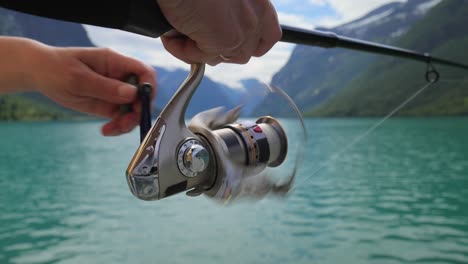 mujer pescando en una caña de pescar girando en noruega.