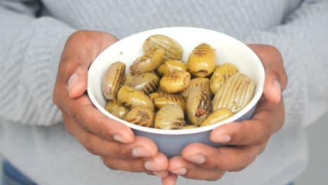 person holding a bowl of olives