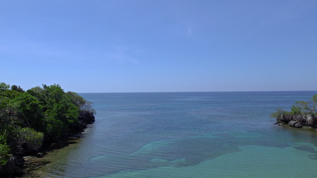 Aerial establishing shot of a quiet bay on the coast of Puerto Plata
