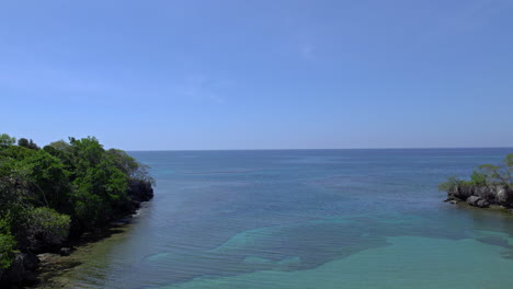 aerial establishing shot of a quiet bay on the coast of puerto plata