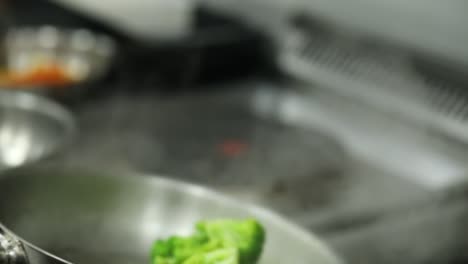 un jefe cocina brócoli en una parrilla cerca de la toma, inserción de la toma