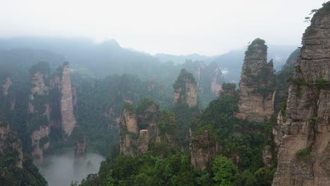 aerial navigates through misty rock columns of zhangjiajie nat'l park