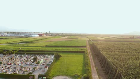 Cemetery-in-Rural-Countryside,-Green-Fields,-Farm-Crops-AERIAL-DESCEND