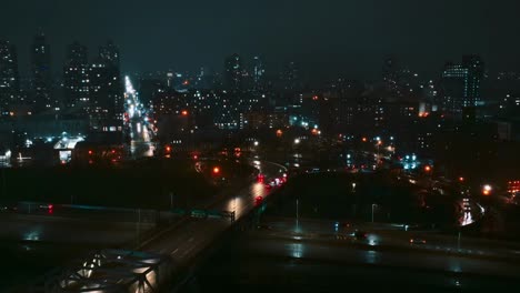 drone flying over rooftop, manhattan skyline at night, highway river