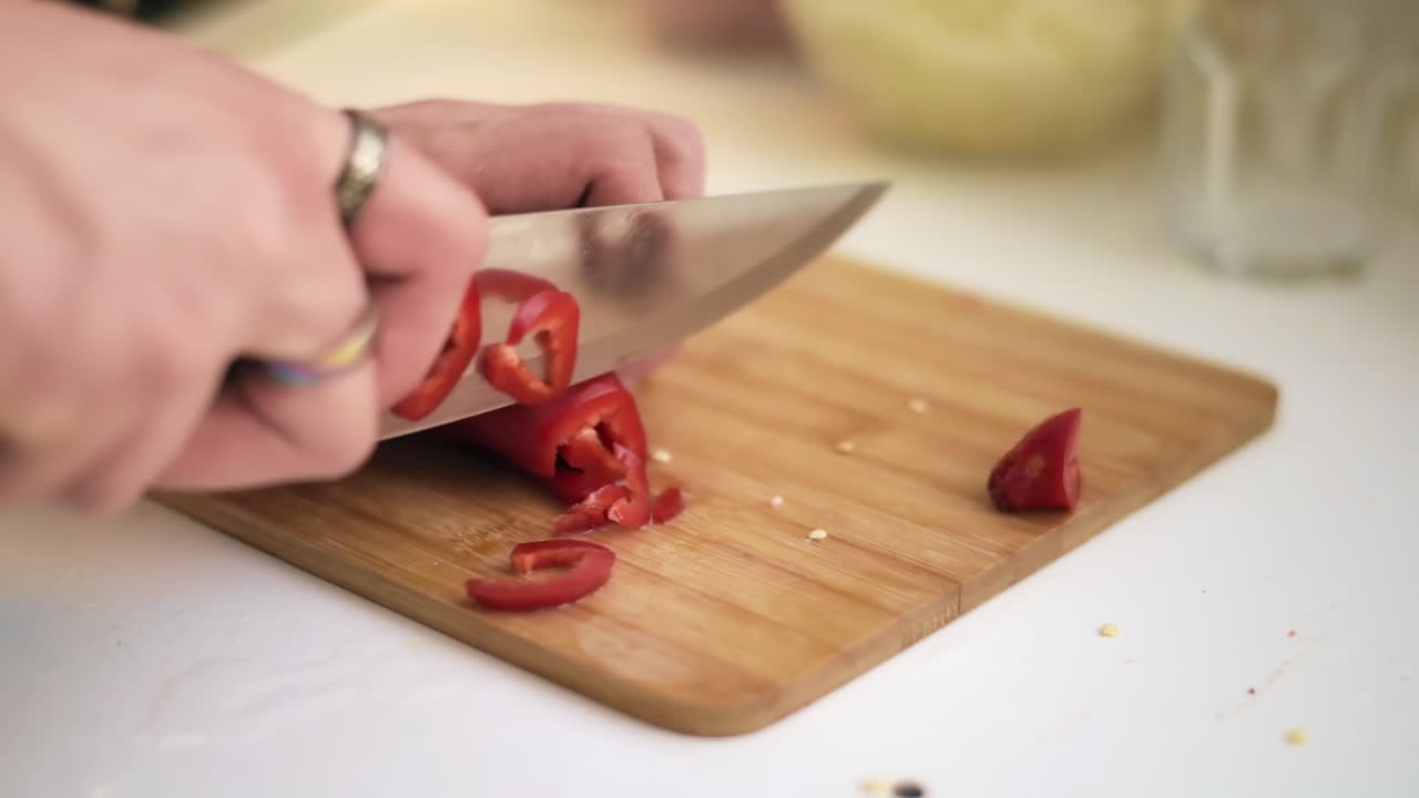 Male hands with rings slicing a pepper. Slow motion