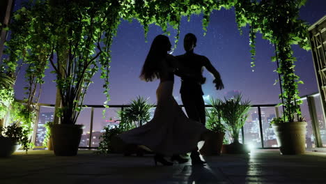 couple dancing on rooftop at night