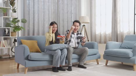 couple playing mobile games on couch