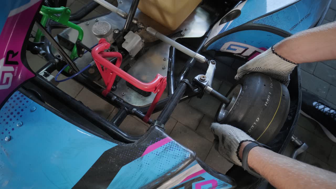 el mecánico del servicio de carreras de go kart cambia las ruedas