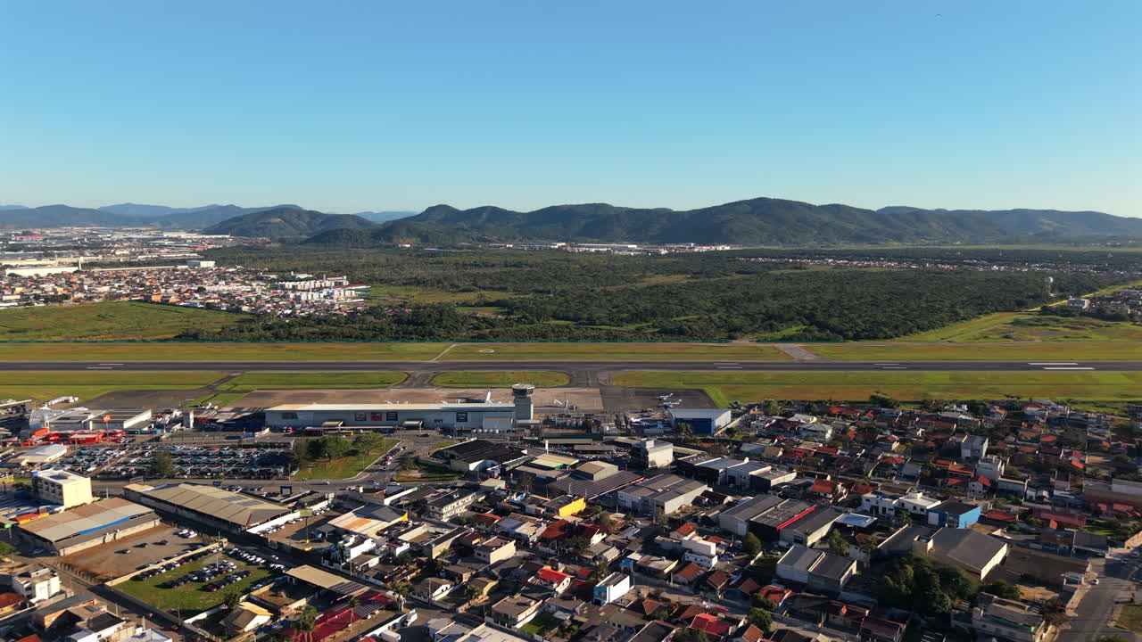 Runway and terminal of Navegantes airport with the city in the background, aerial