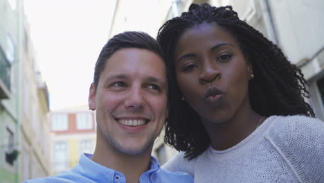 una joven pareja feliz divirtiéndose mientras posa para una selfie.