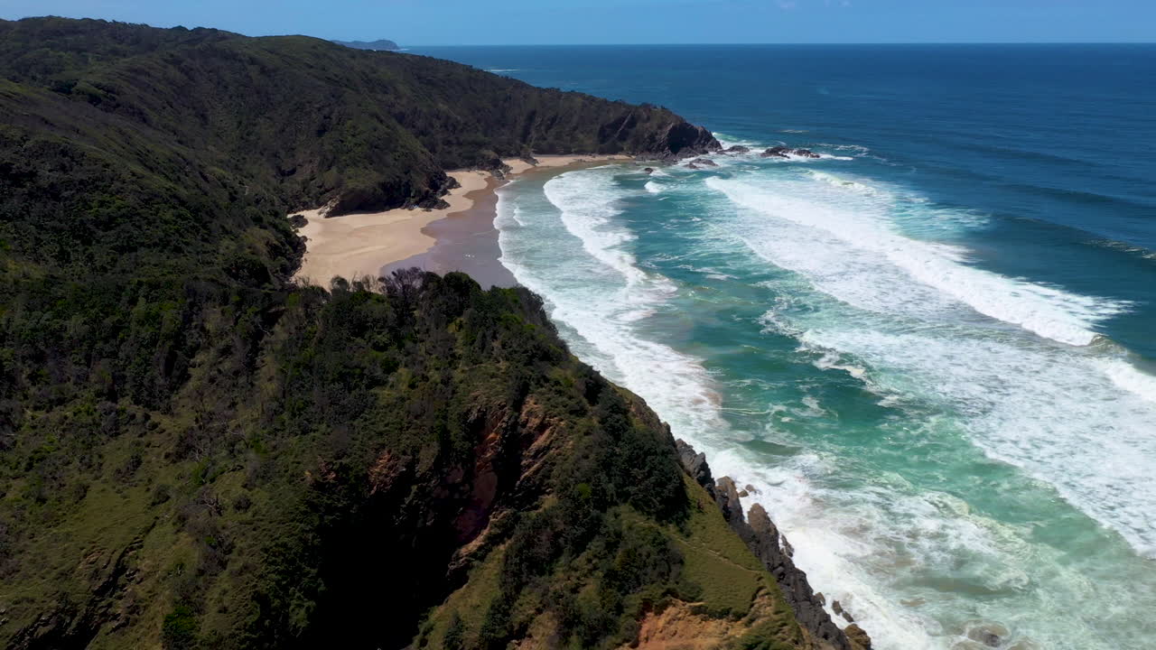 Rivelatrice ripresa cinematografica con drone dell'oceano e di un'isola a Wategos Beach, Australia