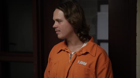 sad, solemn man, inmate, prisoner, walks into prison celll