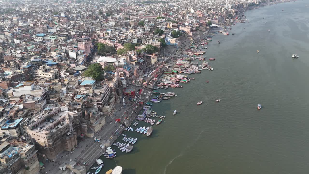High-altitude view of Varanasi's riverfront, where the Ganges flows past ancient stone steps and vibrant marketplaces.