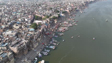 high-altitude view of varanasi's riverfront, where the ganges flows past ancient stone steps and vibrant marketplaces.