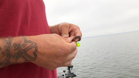 hombre preparando cebo en el gancho de pesca para ir a pescar en el barco