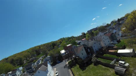 drone fpv flight over houses at street of american town in spring