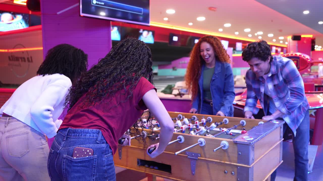 Amigos jugando al futbolín en una sala de juegos