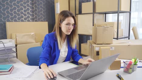 Mujer-De-Negocios-Trabajando-En-Computadora-Y-Rastreando-Pedidos-En-Almacén-De-Embalaje-Y-Carga.