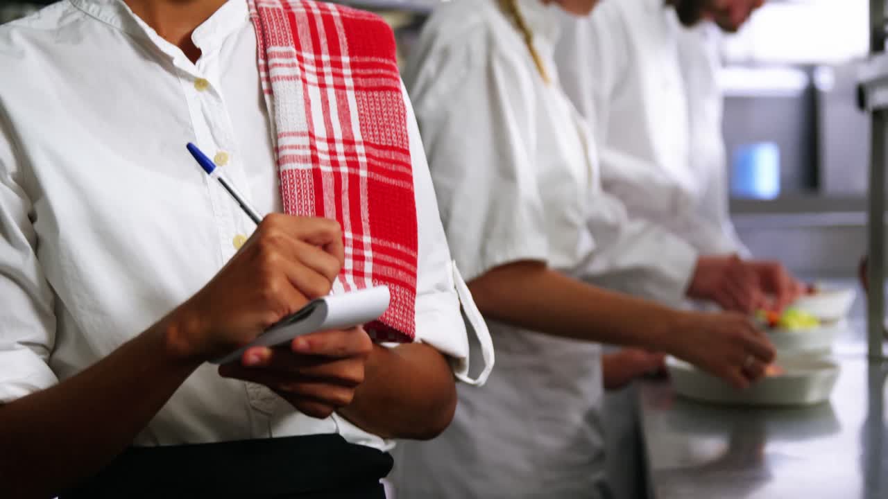 Pelayan dengan blok catatan di dapur