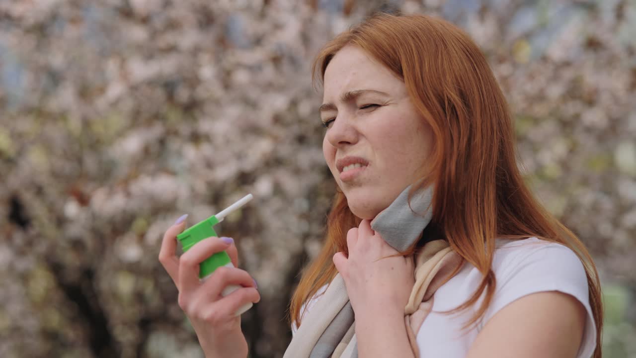 Woman using inhaler outdoors