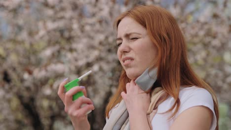 woman using inhaler outdoors