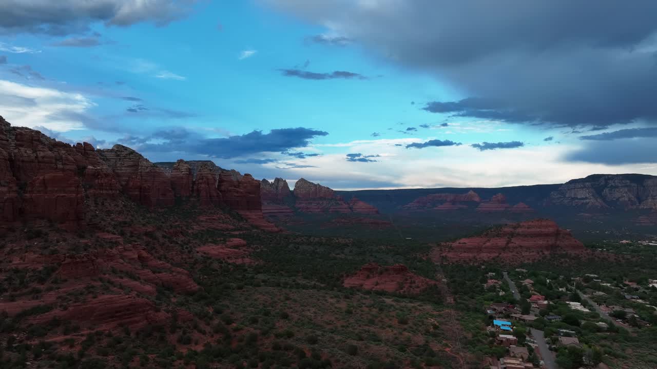 Utsikt over røde fjellformasjoner mot en skyet blå himmel i Sedona, Arizona, USA