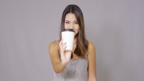 young woman offering a cup of takeaway coffee