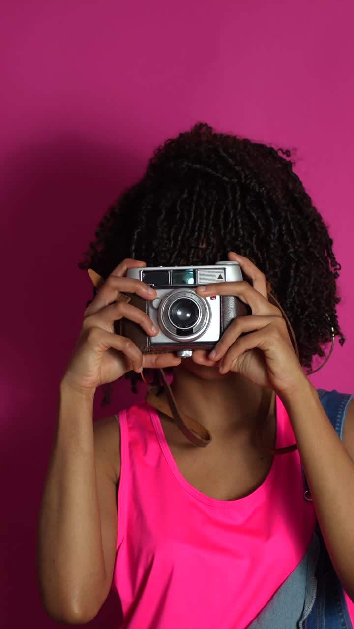 Donna che scatta foto con una macchina fotografica retrò