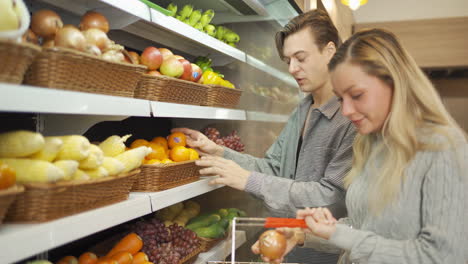 couple shopping for produce at grocery store