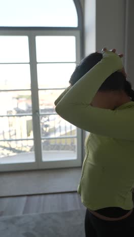 mujer estirándose en un interior de casa