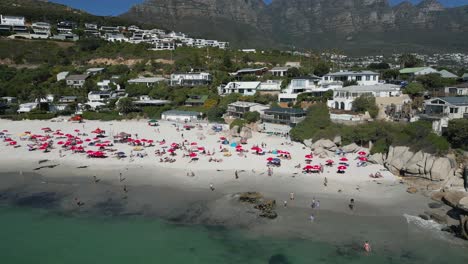 drone shot of umbrellas covering the south african beach in cape town
