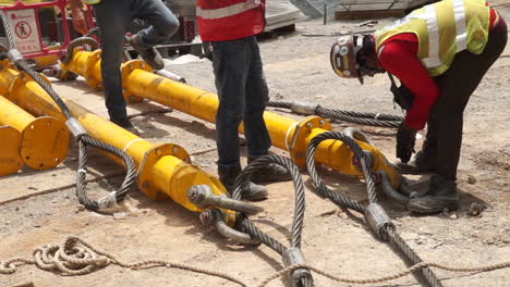 riggers installing shackles and wire ropes on steel columns for erection