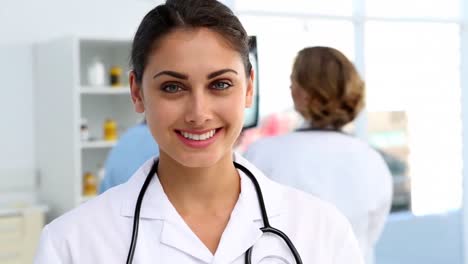 doctor standing and smiling in front of medical team