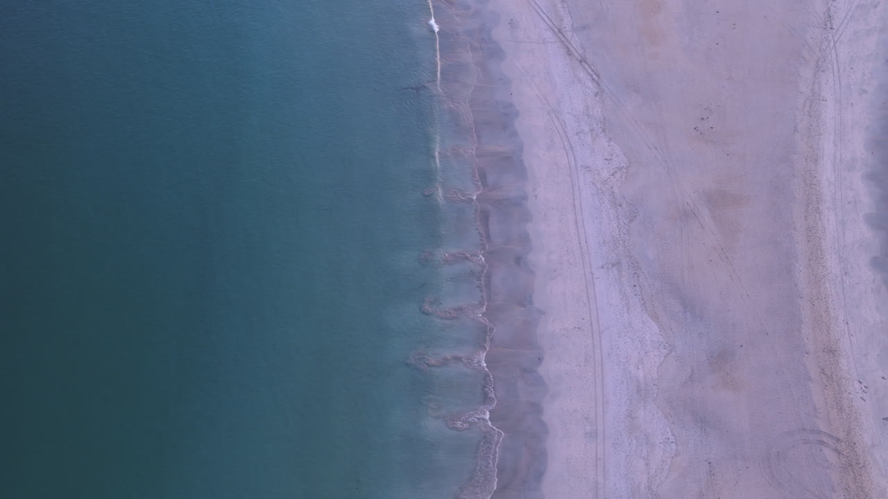 A cropped in aerial shot of St Ninian's beach in Bigton, Shetland at dusk showing the beautiful white sand and blue water