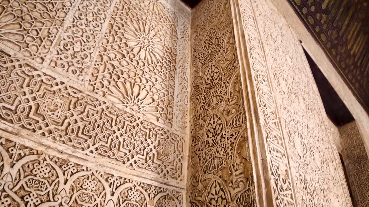 Detail and panoramic shot of the arabesque pattern used as wall finish in the interior of the Alhambra in Granada, Spain