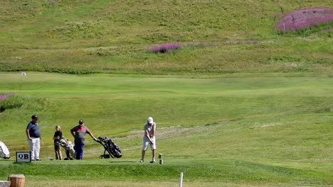 golfers preparing and hitting a shot