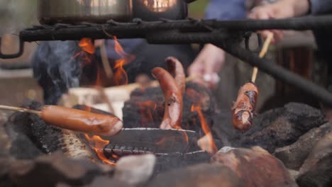 Salchichas-En-Un-Picnic-Sobre-Palos-Cocinando-En-El-Fuego-Con-Teteras-Hechas-De-Metal-Brillante