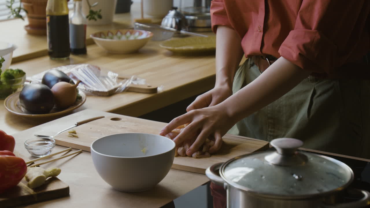 Woman Chopping Chicken in Kitchen for Cooking