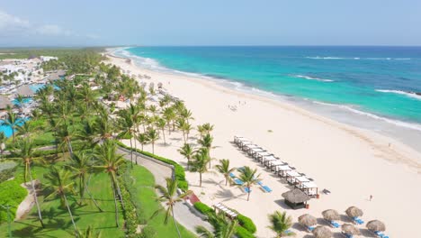 Luftaufnahme-Des-Weißen-Sandstrandes-Mit-Palmen-Und-Seelandschaft-Im-Sommer-In-Der-Nähe-Des-Hard-Rock-Hotels-Und-Des-Casino-Punta-Cana-In-Der-Dominikanischen-Republik