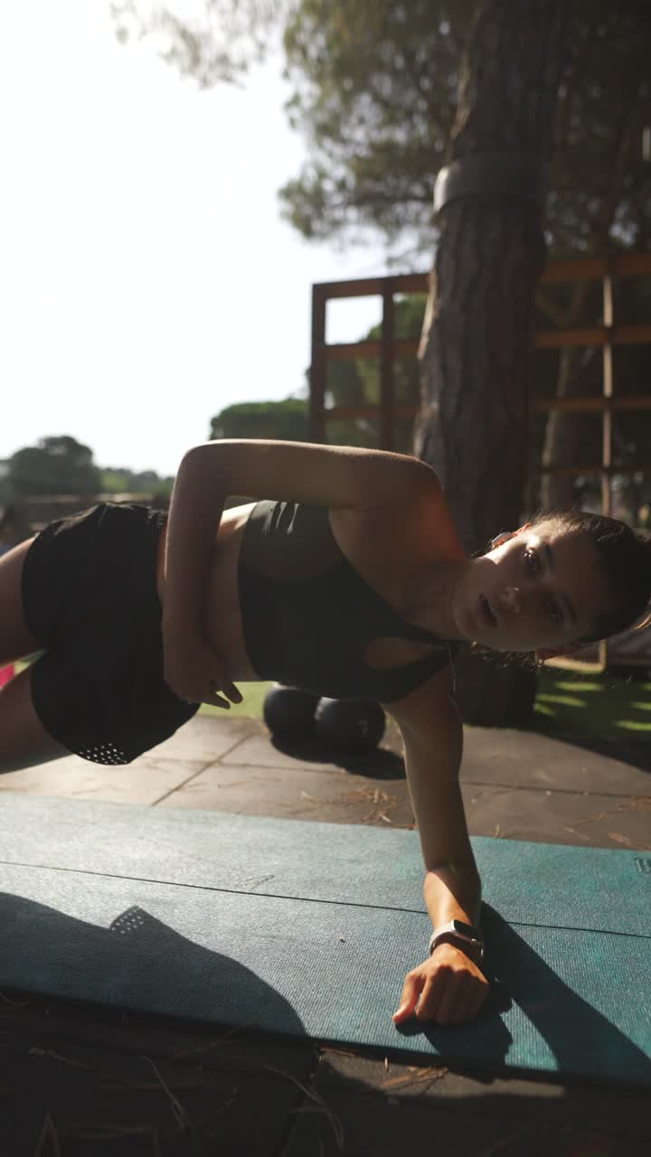 mujer haciendo ejercicio de tabla al aire libre