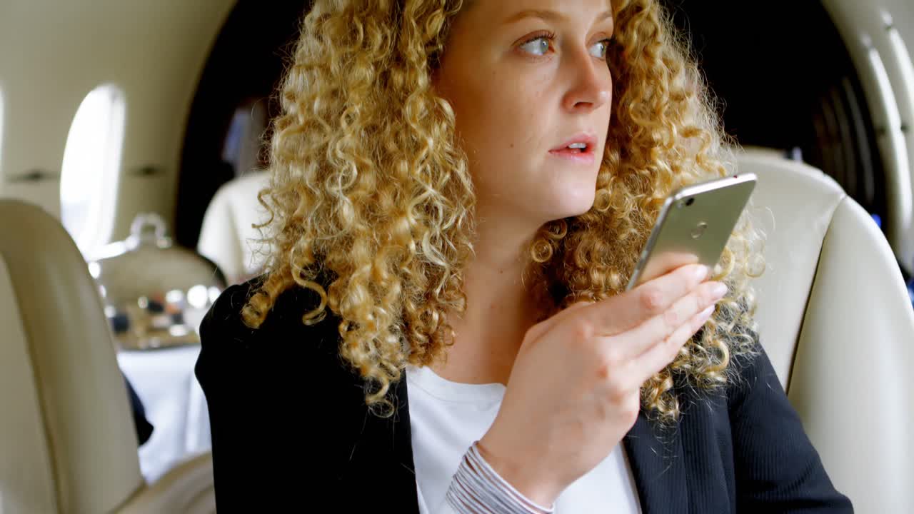 mujer de negocios en una llamada en un jet privado 4k