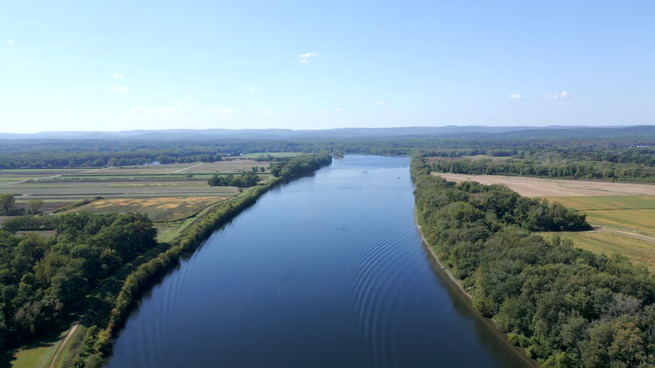 Panorama drone view of Connecticut River stretching across the horizon surrounded by flat rural landscape, Hadley, Massachusetts, USA