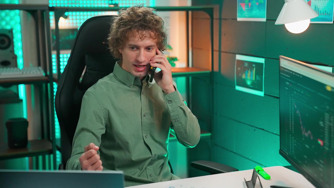 Young Man Talking on Phone While Working in Modern Office