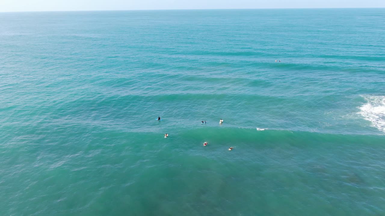 vista de drones de la playa de costa rica que muestra a los surfistas en sus mesas esperando una ola