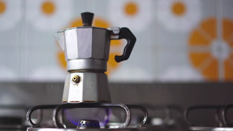 Close-up-of-adult-man-hand-turning-on-gas-stove-with-piezoelectric-gas-lighter-for-making-a-coffee-with-traditional-Italian-neapolitan-moka-machine-4k