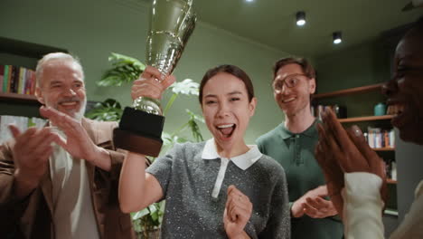 joyful woman celebrates award win with team